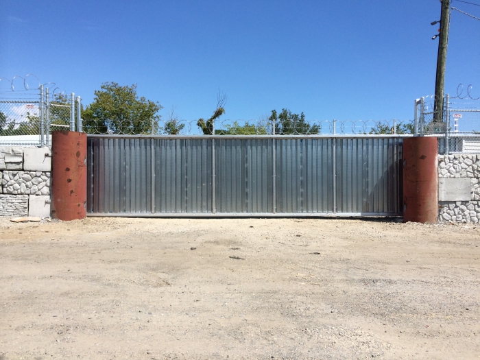 Solid Steel Security Gate with Corrugated Metal and Razor Ribbon